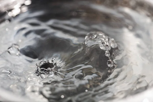 Gotas de agua cayendo sobre la superficie del agua — Foto de Stock