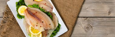 Ahşap arka planda Whitefish Tilapia balık RAW fileto. Seçici odak.