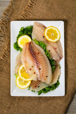 Ahşap arka planda Whitefish Tilapia balık RAW fileto. Seçici odak.