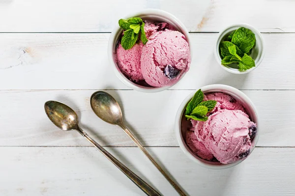 Black Cherry Vanilla Ice Cream or Cherry Frozen Yogurt on White Wooden Background. Selective focus.