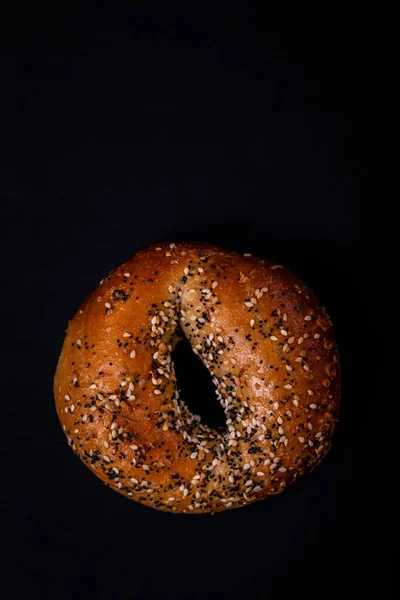 Frissen Sült Bagel Szezámmaggal Mákmaggal Fokhagymával Hagymával Fekete Háttéren Szelektív — Stock Fotó