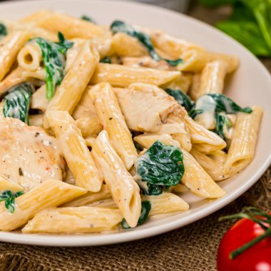 Tahta Arkaplanda ıspanaklı Tavuk Alfredo. Seçici odak.