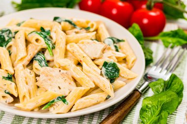 Ispanaklı tavuk Alfredo Parmesan Penne Makarnası. Seçici odak.