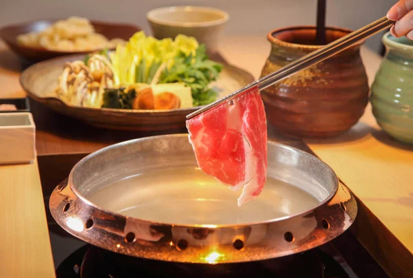 Raw beef getting down boiling in hot pot shabu — Stock Photo, Image