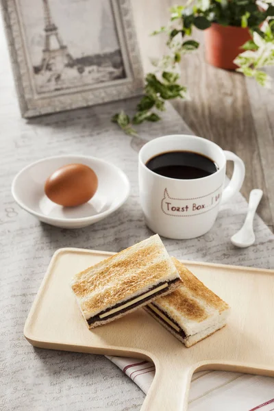Delicioso desayuno con tostadas, huevo y café negro en una plancha — Foto de Stock