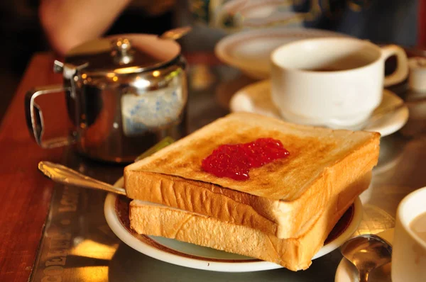 Torrada de café da manhã com geléia de morango e chá inglês — Fotografia de Stock