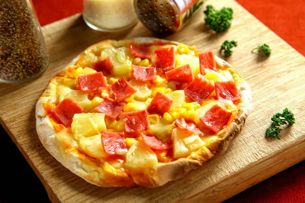 ham and pineapple pizza on wooden table