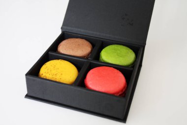 Kara kutu beyaz arka plan üzerinde renkli macarons