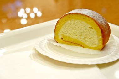 Kremsi İsviçre rulo üzerinde beyaz bir tabak 