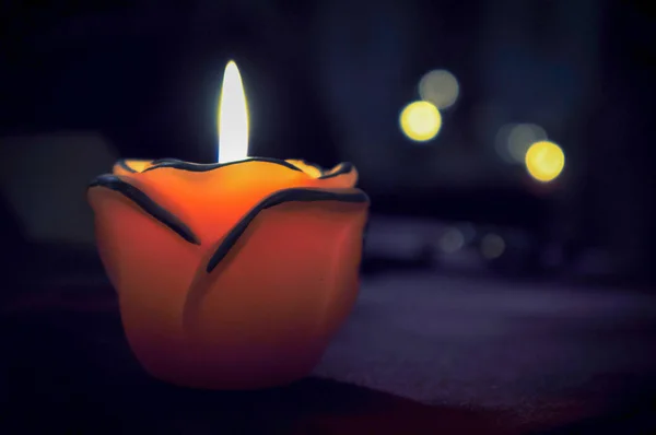 Una candela fiamma luce di notte con bokeh su sfondo scuro — Foto Stock