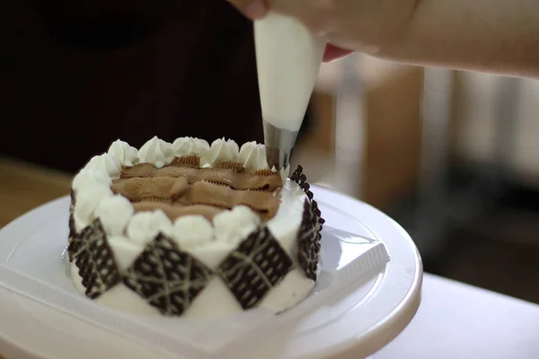 Baker dekorera en tårta, närbild — Stockfoto