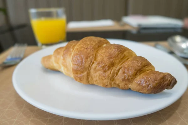 Delicioso café da manhã com croissants frescos na placa branca e ora — Fotografia de Stock