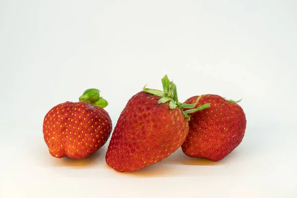 Three perfectly cleaned strawberries with leaves isolated on the white background — Stock Photo, Image