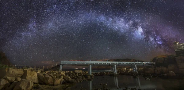 Καμπύλο Milky Way πάνω από μια γέφυρα — Φωτογραφία Αρχείου