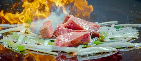 Close up of stir fried beef with flame