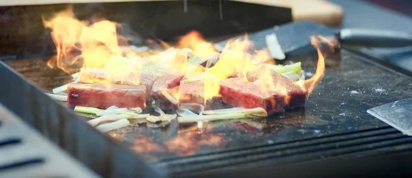 Close up of stir fried beef with flame