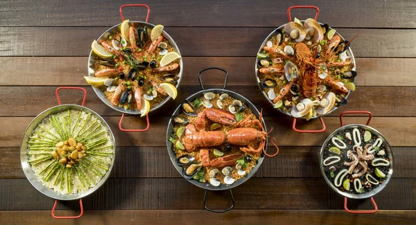 Různé paella na dřevěný stůl, nad zobrazením Stock Obrázky