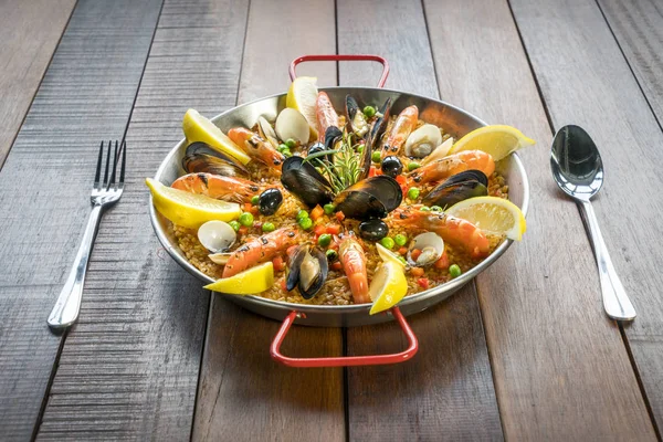 Paella com frutos do mar legumes e açafrão servido na panela tradicional — Fotografia de Stock
