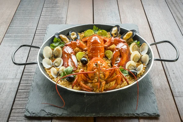 Paella com lagosta fresca, amêijoas, mexilhões e limão — Fotografia de Stock