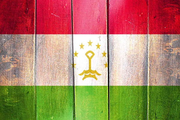 Vintage Vlajka Tádžikistánu na grunge dřevěný panel — Stock fotografie