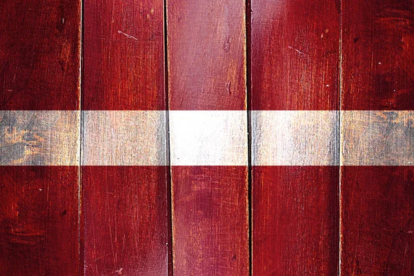 Vintage vlajka Lotyšska na grunge dřevěný panel — Stock fotografie