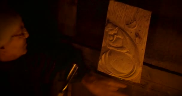 Um escultor de madeira iluminado pela luz de velas — Vídeo de Stock