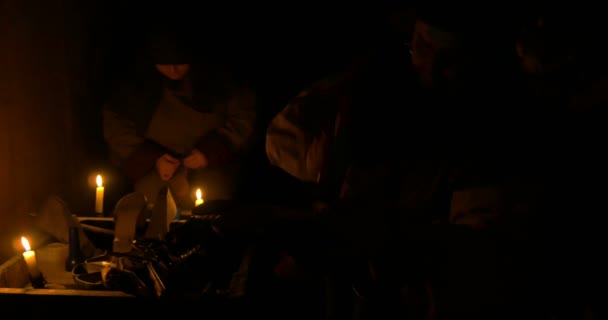 Cobbler la locul de muncă cu instrumente vechi iluminate de lumina lumânărilor — Videoclip de stoc