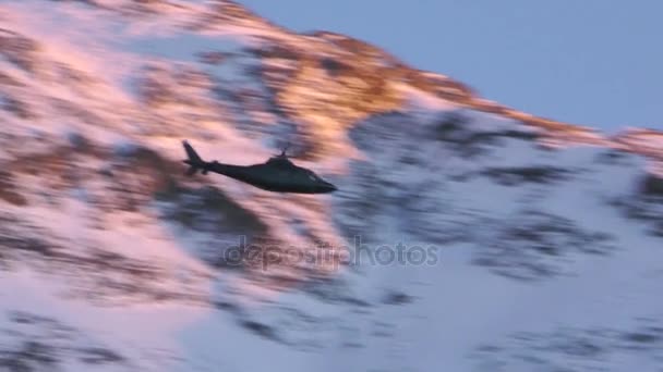 Черный вертолет летит над горой — стоковое видео