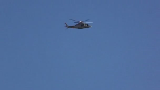 Bílé vrtulník letící proti modré obloze — Stock video