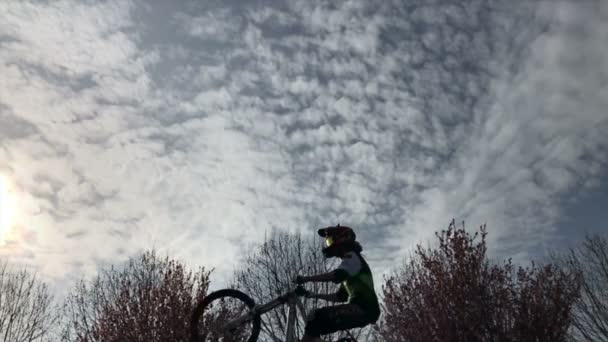 Chico montando en bicicleta realizando un truco — Vídeo de stock
