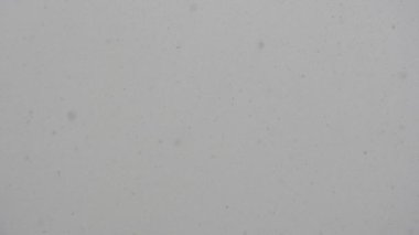 Kar yağışı bulutlu gökyüzü üzerinde ağır çekimde. Gerçek yağan kar. Uçan Kar taneleri