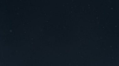 Kar yağışı gece gökyüzü üzerinde ağır çekimde. Gerçek yağan kar. Uçan Kar taneleri