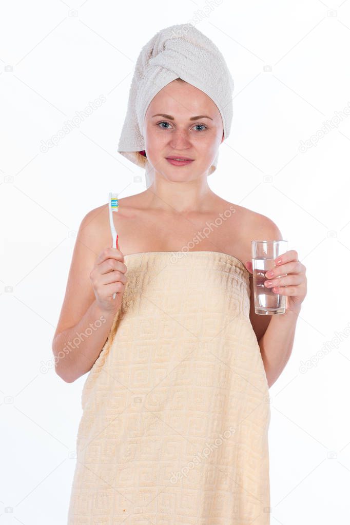 girl in towel cleans teeth