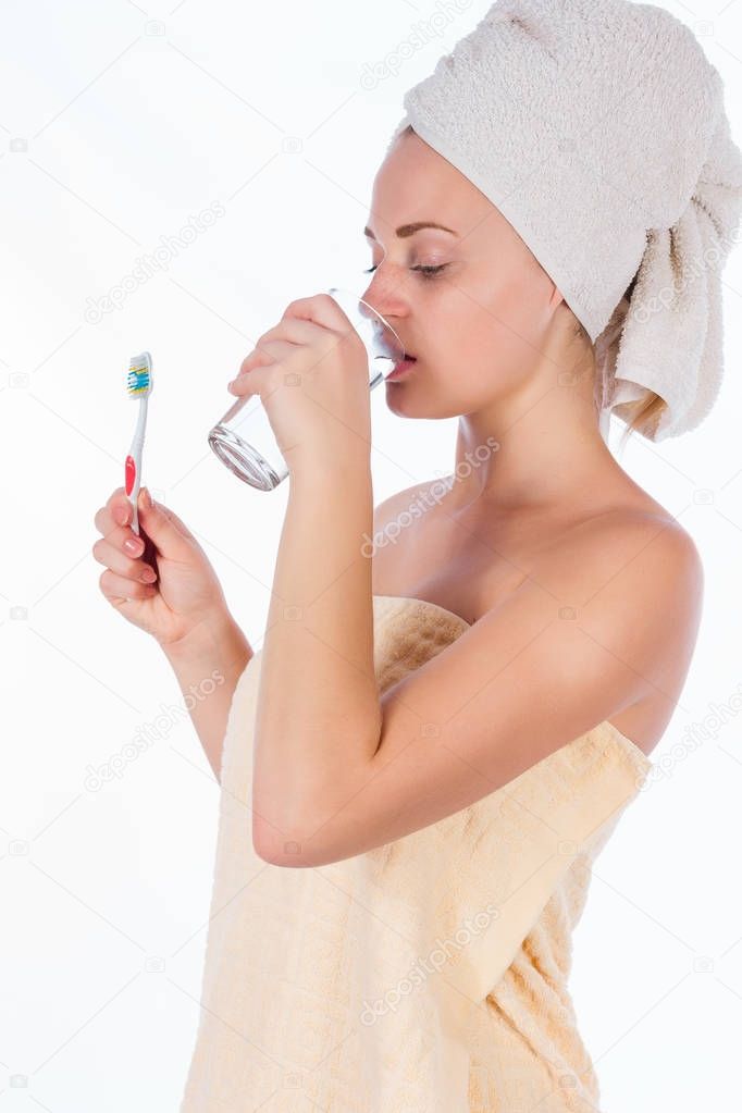 girl in towel cleans teeth