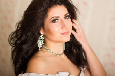 Stüdyo güzel bir genç kadının portresi. Esmer kız ile saç modeli, gelin gibi giyiyor. O beyaz korse aksesuarlar ile. Yumuşak odak