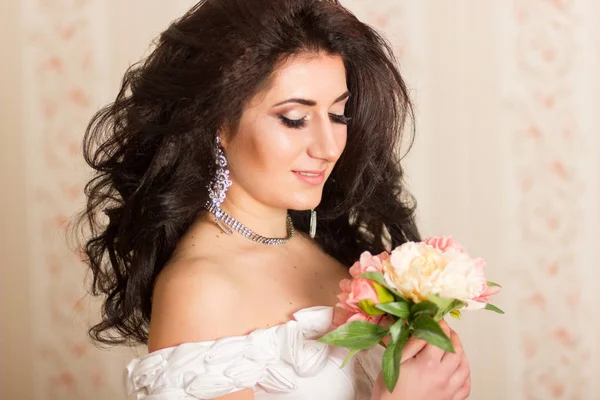 Студийный портрет красивой молодой женщины. Брюнетка с прической, одетая как невеста. Она в белом корсете с аксессуарами. Мягкий фокус — стоковое фото