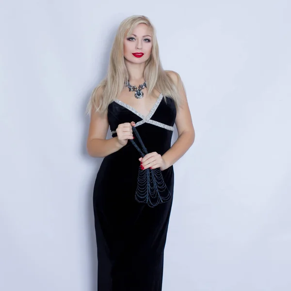 Young beautiful blonde woman in black evening dress — Stock Photo, Image