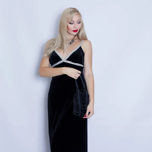 Молода красива блондинка в чорній вечірній сукні — стокове фото