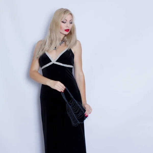 Молода красива блондинка в чорній вечірній сукні — стокове фото
