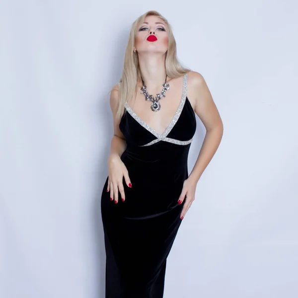 Beautiful blonde woman in black evening dress — Stock Photo, Image