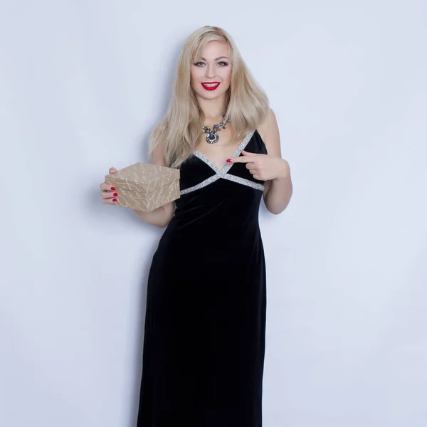 Vacker elegant unga blonda kvinnan i svart aftonklänning holding presentbox — Stockfoto