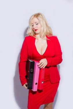 Güzel bir sarışın genç kadın kırmızı iş takım elbiseli portresi. Kız bir klasör belgeler için tutar