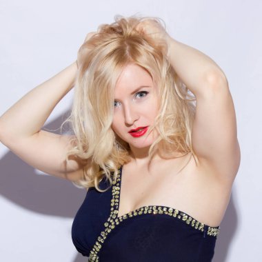 Stüdyo portre genç, güzel bir sarışın kadın mavi gece elbisesi ve uzun elmas küpe