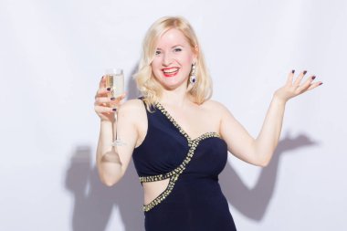 Güzel bir sarışın genç kadın mavi uzun gece elbisesi içinde stüdyo portre. Bir kız bir kadeh şampanya elinde tutuyor