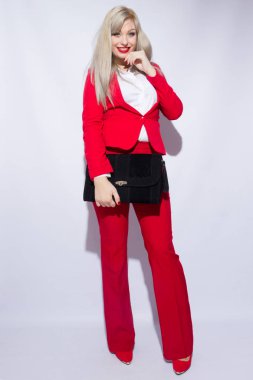 Kırmızı elbiseli uzun saçlı güzel bir genç sarışın kadın portresi. O onun elinde büyük bir siyah debriyaj tutar