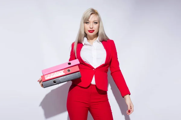 Portrait of a beautiful secretary in a red suit with folders in hand