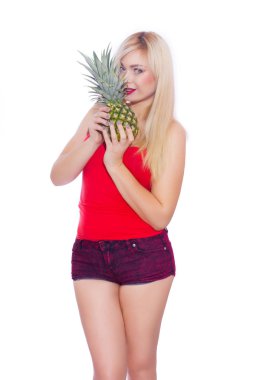 Ananas saklanıyor ve kameraya bakarak parlak makyaj ile sarışın kız