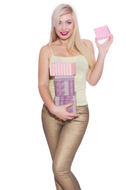 Studio fotoğraf güzel bir genç sarışın kadının uzun saçlı bir yaz ışık sarı mayoyu ve altın kot pantolon giymiş. Kız hediye kutuları tutuyor. Bir model beyaz bir arka plan karşı teşkil etmektedir.. 
