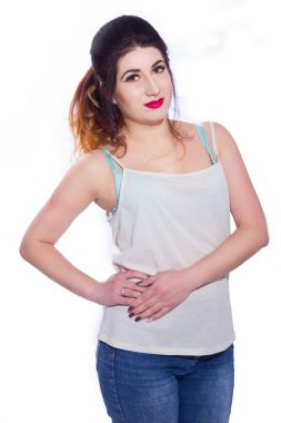 Stüdyo portre siyah saçlı güzel bir genç kadının bir kuyrukta toplandı. Kız beyaz bir arka plan karşı bir T-shirt ve jeans teşkil etmektedir. Kameraya bakıyor. İzole