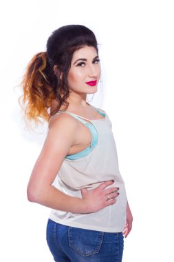 Stüdyo portre siyah saçlı güzel bir genç kadının bir kuyrukta toplandı. Kız beyaz bir arka plan karşı bir T-shirt ve jeans teşkil etmektedir. Kameraya bakıyor. İzole